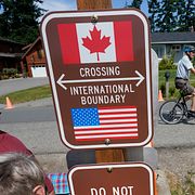 En skylt vid gränsen mellan USA och Kanada i Peace Arch Historical State Park.