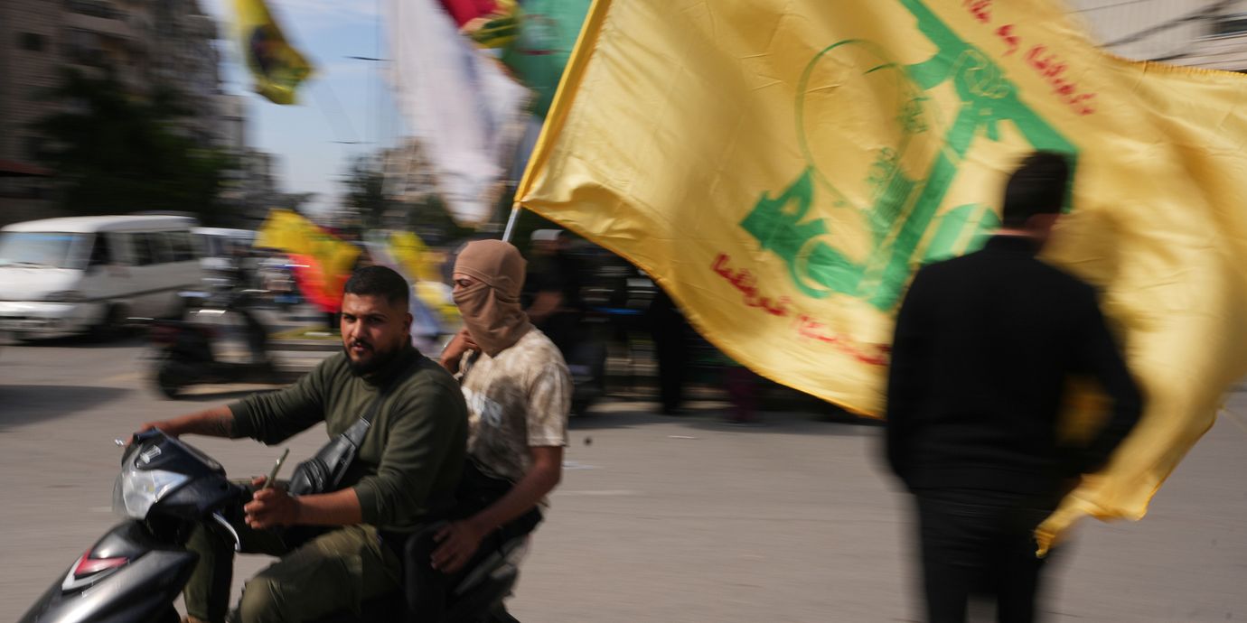 Män med Hizbollahflagga i södra Libanon den 25 april 2026.