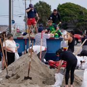 Människor i Long Beach, Kalifornien, fyller sanssäckar på lördagen. Damian Dovarganes / AP