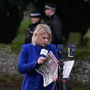 En journalist med en tidning som rapporterar om gripandet av tidigare prins Andrew.