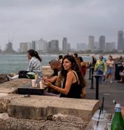 Människor vid en bar vid Medelhavet i Tel Aviv. Illustrationsbild. 