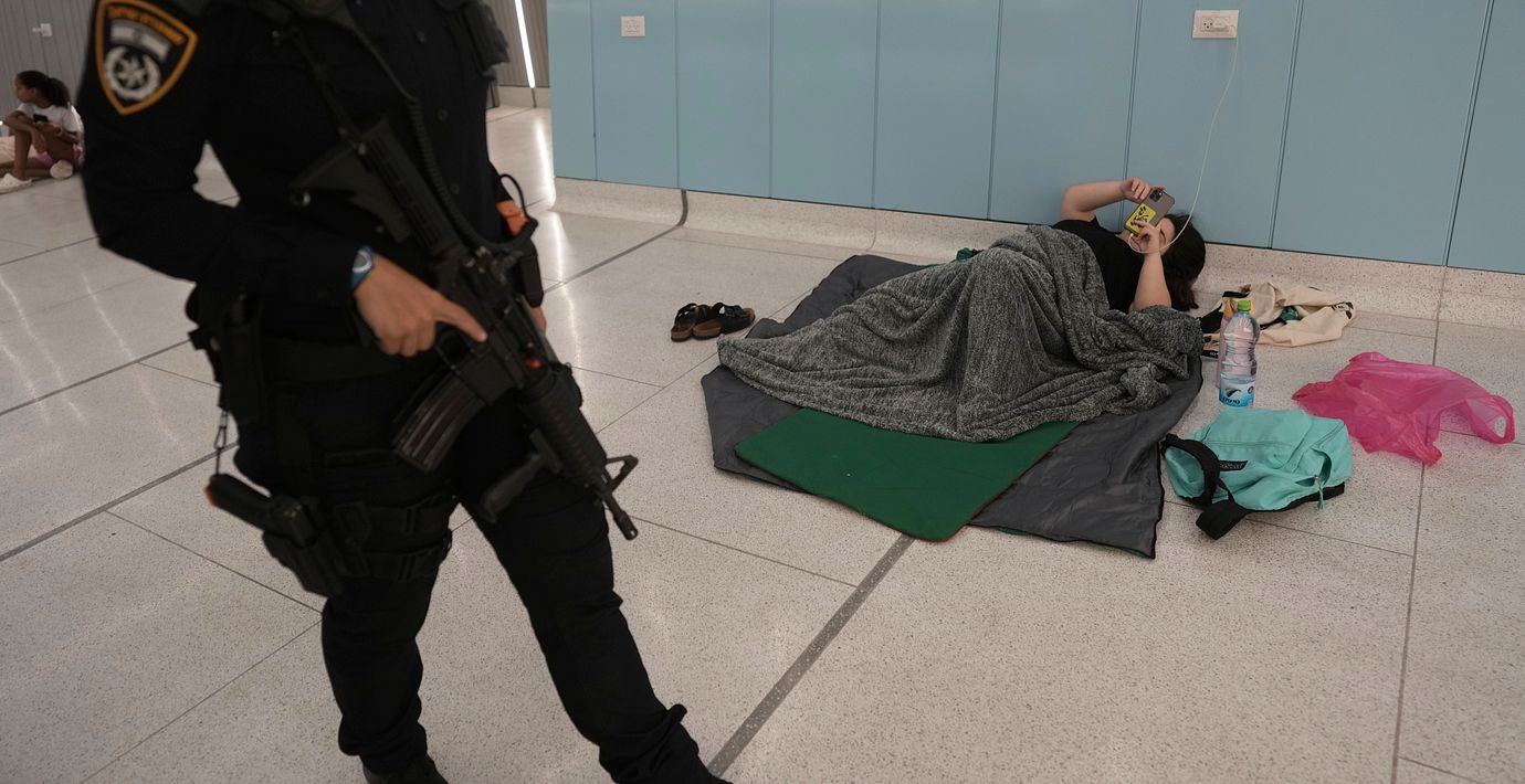 Israelisk polis på patrull samtidigt som människor söker skydd i en tunnelbanestation. Arkivbild.