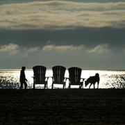 En person går på en strand en morgon.