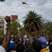 En arméhelikopter flyger över demonstranter som kräver att Mugabe avgår på lördagen.