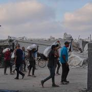 Palestinier bär på matsäckar efter att nödhjälp delats ut.