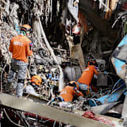 Räddningsarbetare på plats vid rasmassorna i Cebu City.