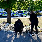 Människor lägger blommor utanför Brinellskolan i Fagersta på måndagen, där ett skoldåd inträffade på fredagen.