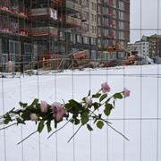  Blommor och kondoleanshälsningar vid byggarbetsplatsen. Arkivbild.