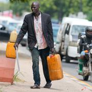 En man säljer bränsle på den svarta marknaden i Lagos, Nigeria efter att bränslepriserna ökar kraftigt. 