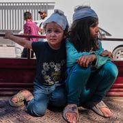 De palestinska systrarna Nadin Naser, 8, och Dana Naser, 3, sitter på flaket till en bil utanför ett sjukhus i Gaza stad den 27 juni.