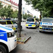 Polisbilar på plats utanför lägenheten där kvinnan hittades död.
