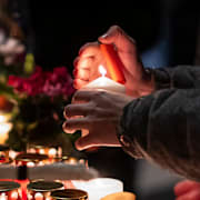 Människor tänder ljus utanför baren, 1 januari. 