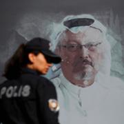 En turkisk polis framför en bild på den mördade journalisten Jamal Khashoggi. 