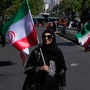 Kvinna med iransk plagga under parad för den mördade ayatollan i Teheran.