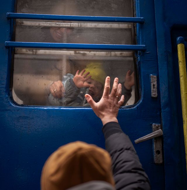 Stanislav, 40, says goodbye to his son David, 2, and his wife Anna, 35, on a train to Lviv at the Kyiv station, Ukraine, Thursday, March 3. 2022. Stanislav is staying to fight while his family is leaving the country to seek refuge in a neighbouring country. Emilio Morenatti / AP