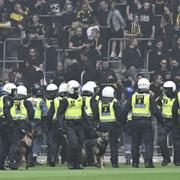 Poliser med hundar på plan framför AIK:s supportrar under fotbollsmatchen i allsvenskan mellan Djurgårdens IF och AIK på Tele2 Arena i Stockholm.
