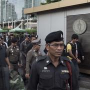 En annan misstänkt syns här med polis vid en iscensättning av händelserna i Bangkok