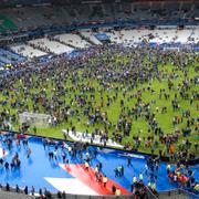 Publiken sökte sig ned från läktarna på planen efter explosionerna utanför Stade de France på fredagskvällen.