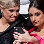 Magdalena Andersson (S) och Nooshi Dadgostar (V) med en mobil.