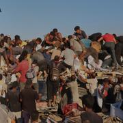 Palestinier försöker få tag i mat från en lastbil i Gaza den 4 augusti.
