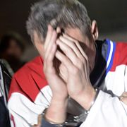 Mannen förs bort efter gripandet.