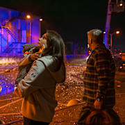 Människor tittar på när räddningstjänsten arbetar efter ryska attacker mot Kyiv.