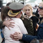 Militärofficer tröstar en anhörig till en av de försvunna besättningsmännen.