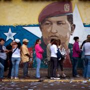Väljare köar till vallokalen nedanför en väggmålning av förre presidenten Hugo Chavez