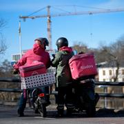Två mopedburna matbud i Stockholm.