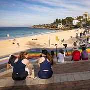 Människor sitter vid Coogee beach efter lördagens hajattack.
