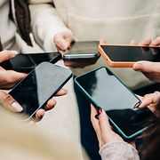 Unga personer som håller mobiltelefoner.