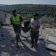 En räddningsarbetare bär på en liksäck i Ansar i södra Libanon efter lördagens israeliska attacker.