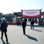 Människor väntar i kö inför vaccinering i klubblokalen Fållan i Stockholm. 