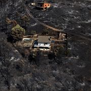 FILE - An area scorched by a wildfire surrounds structures in El Tiemblo, Avila province, Spain, Thursday, July 30, 2026. (AP Photo/Manu Fernandez, File)  CLI404