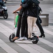 Tre personer åker på en elsparkcykel.
