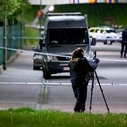 Polisens kriminaltekniker arbetar innanför avspärrningarna efter skjutningen i Malmö.