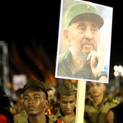 En man håller upp en bild på Fidel Castro under en hyllningsceremoni i Santiago de Cuba den 4 december.