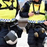 Poliser med hjälm, GoPro kamera, skyddsglasögon och hörselkåpor. Illustrationsbild.