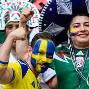 Mexikanska fotbollsälskare krokar arm med svenska fans.