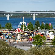 Vy över Sundsvall, med Sundsvallsbron i bakgrunden och i förgrunden Axels tivoli, ett kringresande nöjesfält. Arkivbild.