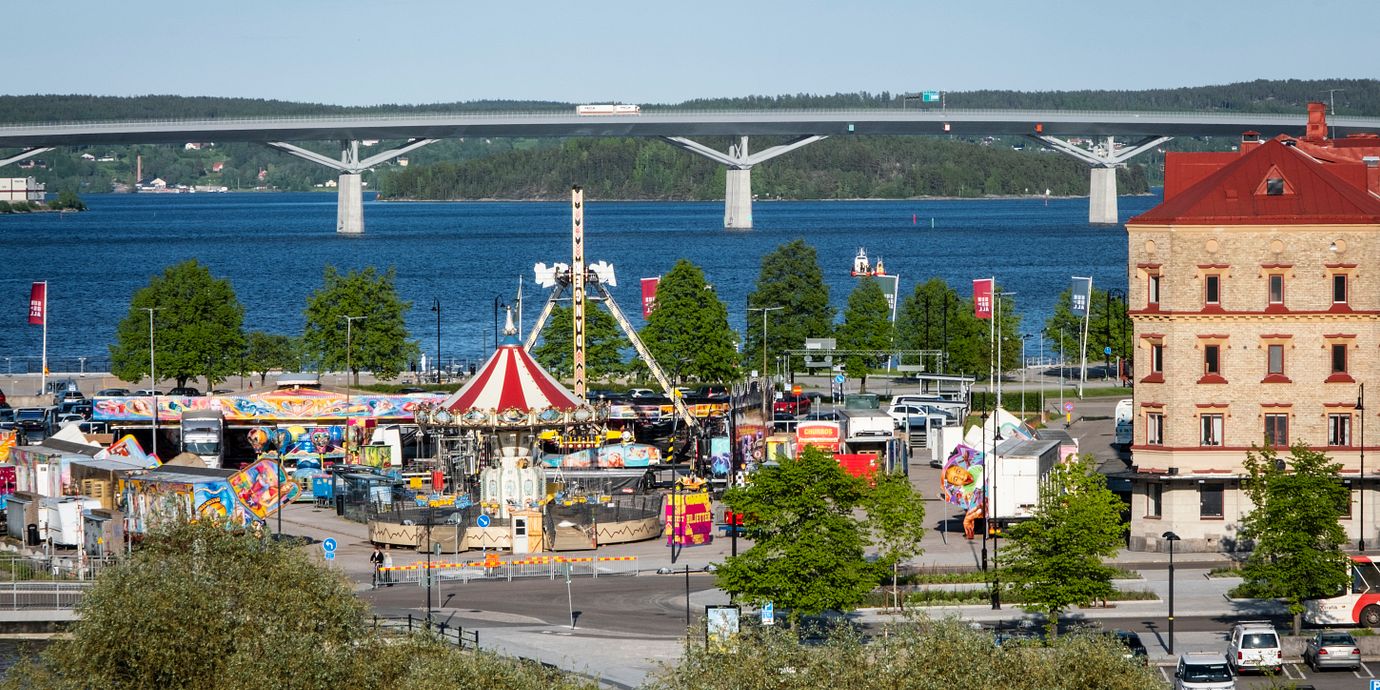Vy över Sundsvall, med Sundsvallsbron i bakgrunden och i förgrunden Axels tivoli, ett kringresande nöjesfält. Arkivbild.