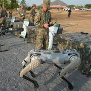 En kinesisk soldat testar en av ”robothundarna” under militärövningen ”Gyllene draken”. 