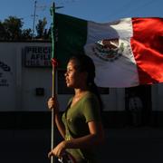 Illustrationsbild. En kvinna håller upp en mexikansk flagga under en demonstration mot våldet i Ciudad Juarez, 23 juni. 