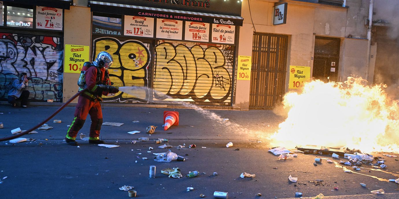  En brandman släcker en eld efter demonstrationer i Paris.