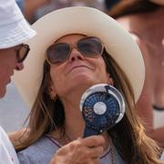 Åskådare till en tennismatch svalkar sig i London, 20 juni 2025. 
