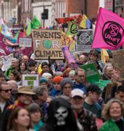 Klimatdemonstranter utanför parlamentet i London på fredagen.  Kin Cheung / AP