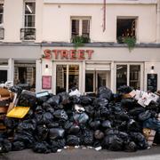 Sophögarna växer i Paris. På vissa ställen ligger det så mycket sopsäckar att fotgängare inte längre kan ta sig fram och butikerna nästan inte går att skymta.
