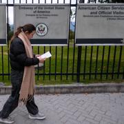 Kvinna i Colombia läser visuminformation vid USA:s ambassad.