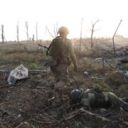 Ukrainsk soldat passerar rysk soldat, arkivbild. 