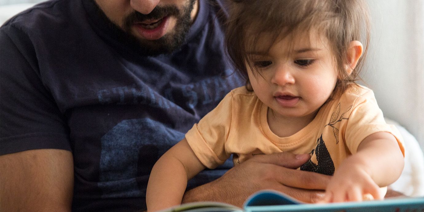 Föräldraledig pappa läser en saga för sin dotter.